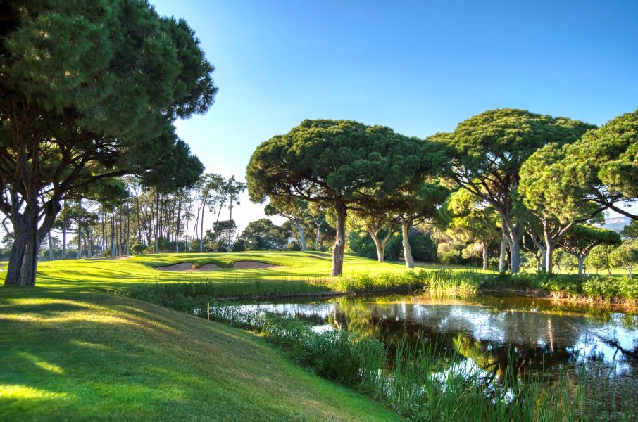 Green trees and blue lake at Dom Pedro Golf Old Course in Vilamoura