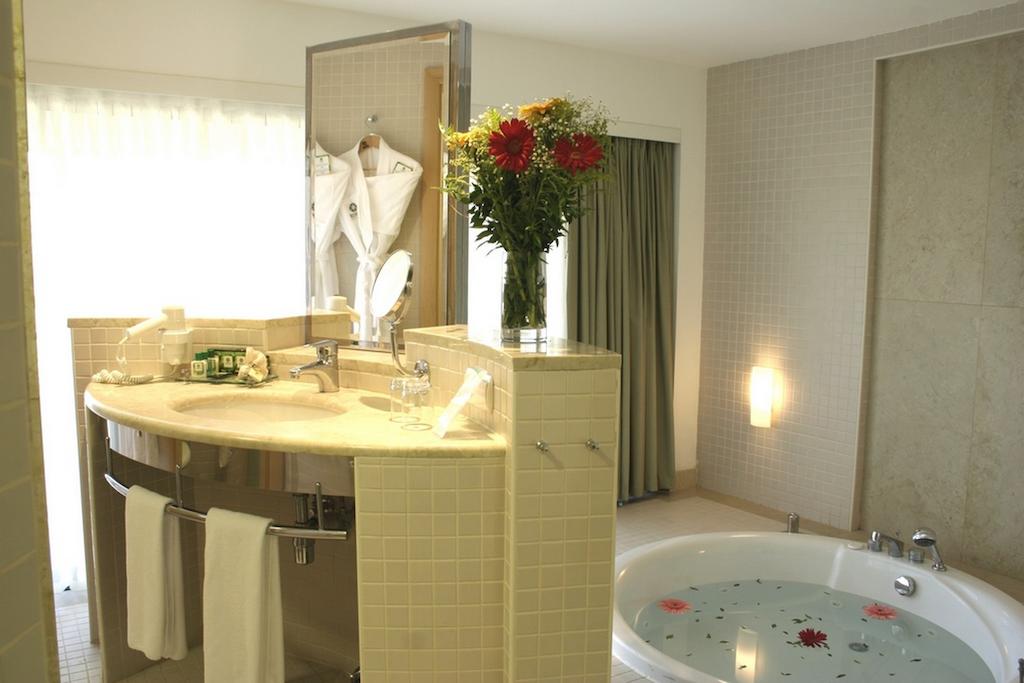 Sink, mirror, and bath tub in private bathroom at Cornelia Deluxe Resort