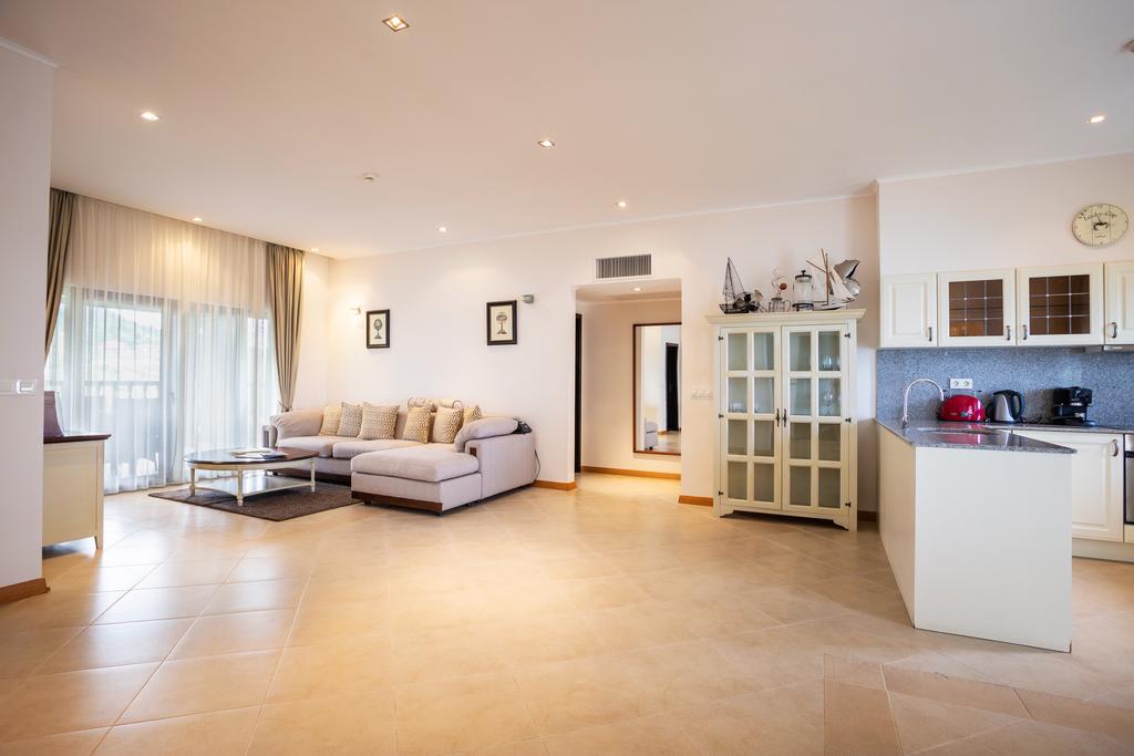 Living area and kitchen at Thracian Cliffs Golf & Beach Resort with sofa, table, and tiled floor
