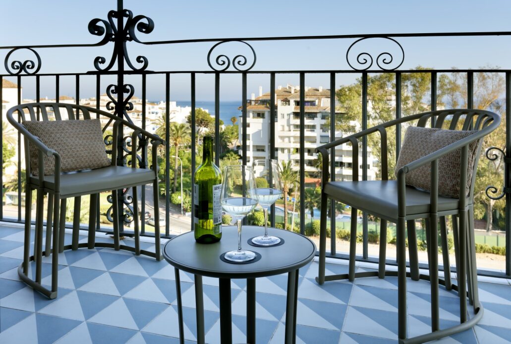 Balcony at Hard Rock Hotel Marbella with table and two chairs overlooking the resort