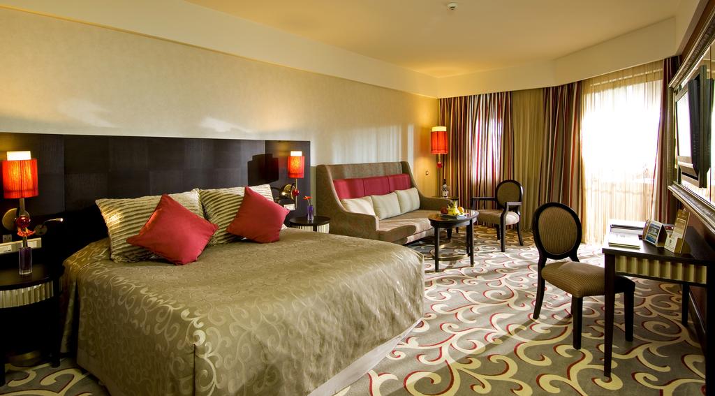 Double bedroom with sofa, desk, and television at Cornelia Diamond Resort