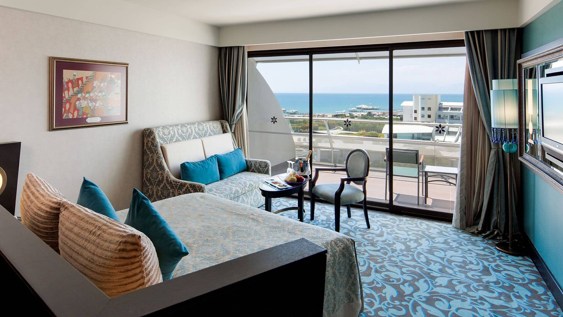 Double bedroom with sofa, chair, balcony, and television at Cornelia Diamond Resort