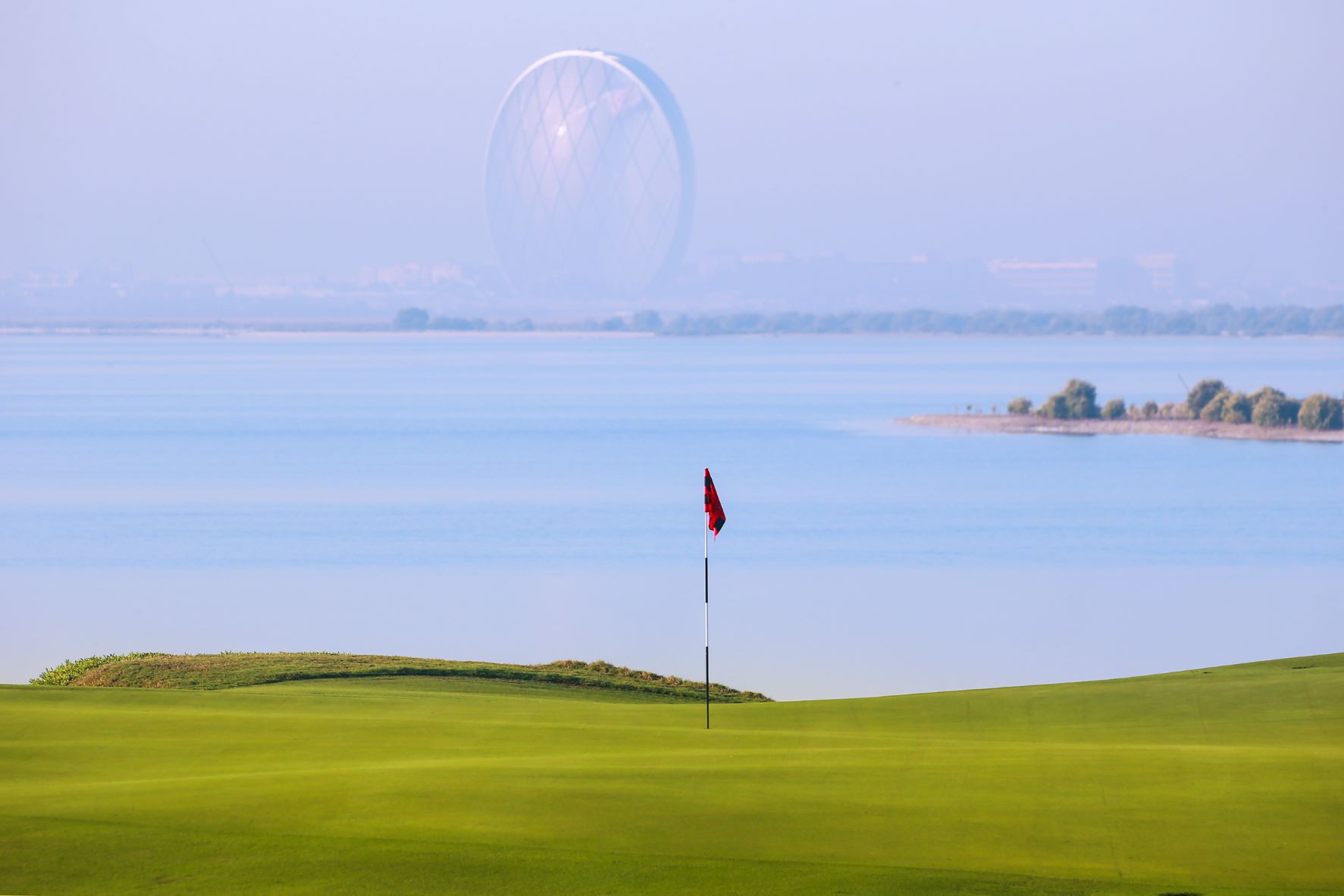 Flag on the green at Yas Links Golf Club