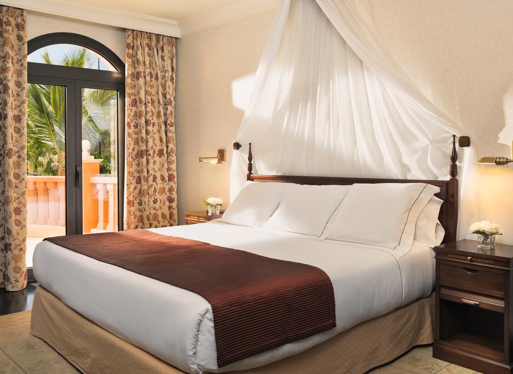 Double bedroom at Hotel Las Madrigueras Golf Resort And Spa with wooden bedside tables and private balcony