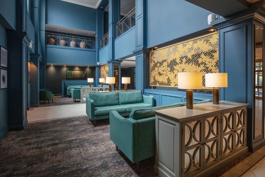 Green sofas in lobby area with blue walls at Belton Woods Hotel, Spa And Golf Resort