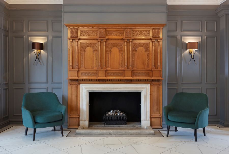 Two green chairs in front of fireplace at Belton Woods Hotel, Spa And Golf Resort
