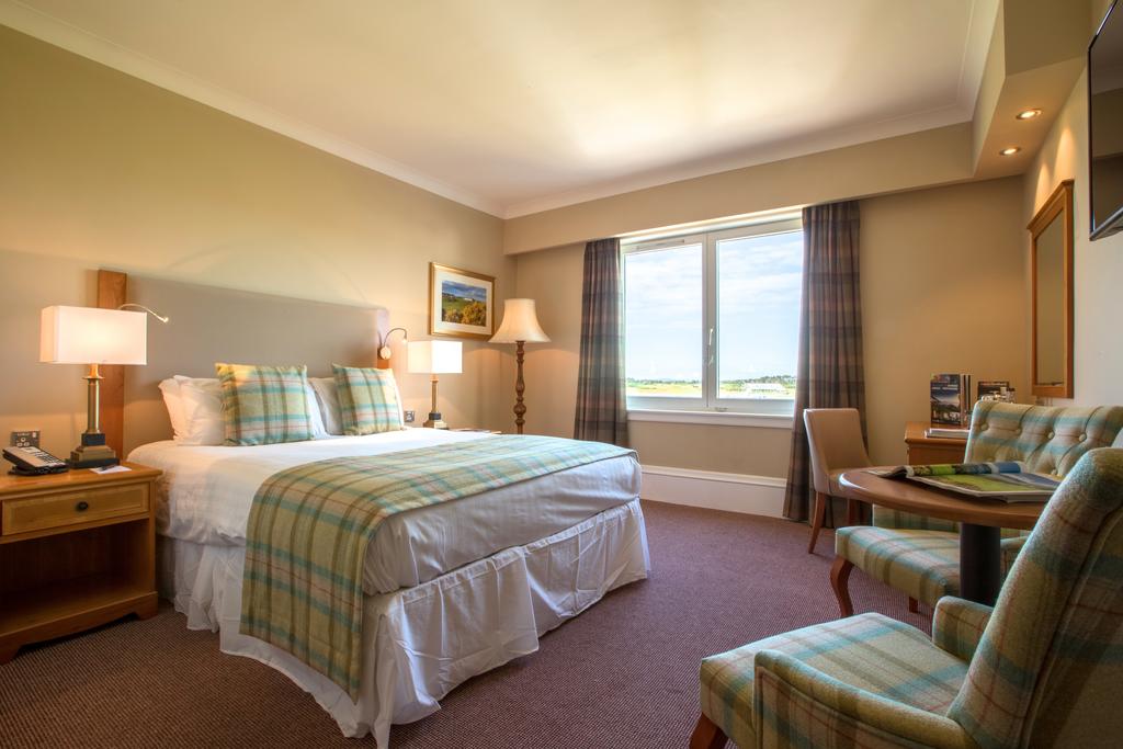 Double bedroom with desk, television and furniture at Carnoustie Golf Hotel And Spa