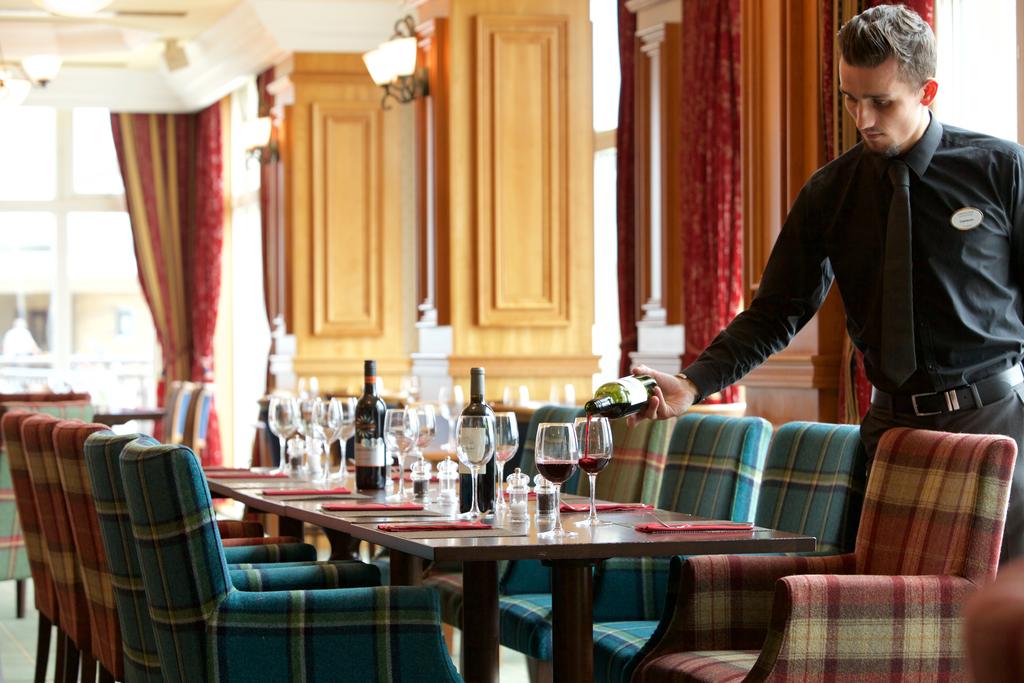 Waiter pouring red wine in the restaurant at Carnoustie Golf Hotel And Spa