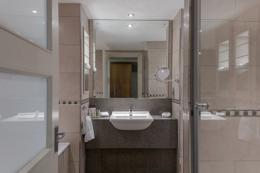 Bathroom with sink and mirror in bedroom at Glasgow Westerwood Hotel, Spa & Golf Resort
