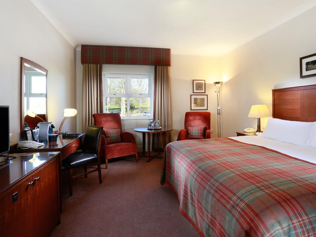 Bedroom with double bed decorated in a tartan theme at MacDonald Portal Hotel Golf And Spa