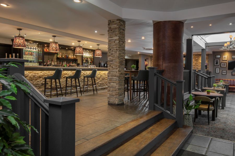 Stairs leading to bar area with stools alongside it at Slaley Hall Hotel, Spa And Golf Resort