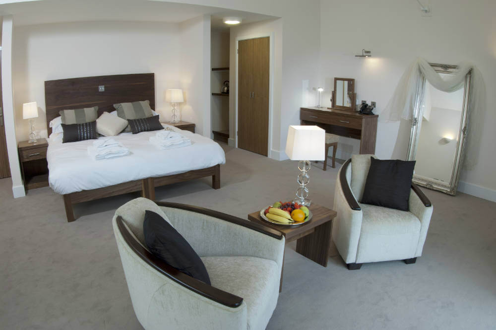 Bedroom with double bed, fruit bowl, mirror and furniture at Prince's Golf Club