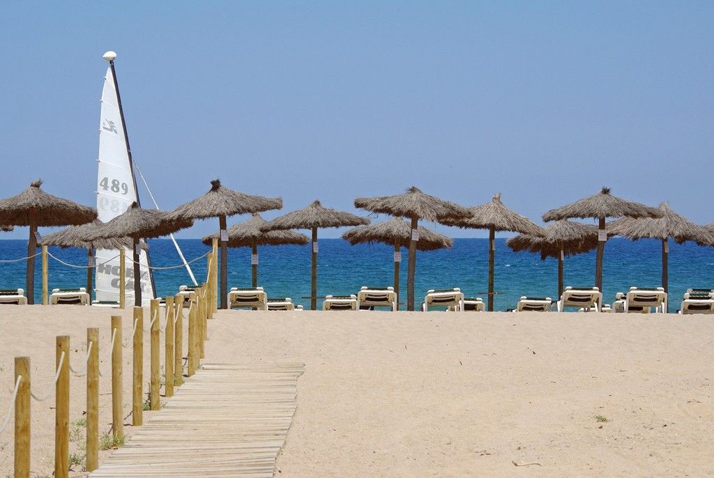 Beach with parasols and sun loungers at La Costa Golf and Beach Resort