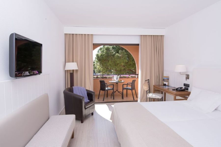 Bedroom with balcony and flat screen television at La Costa Golf & Beach in Girona