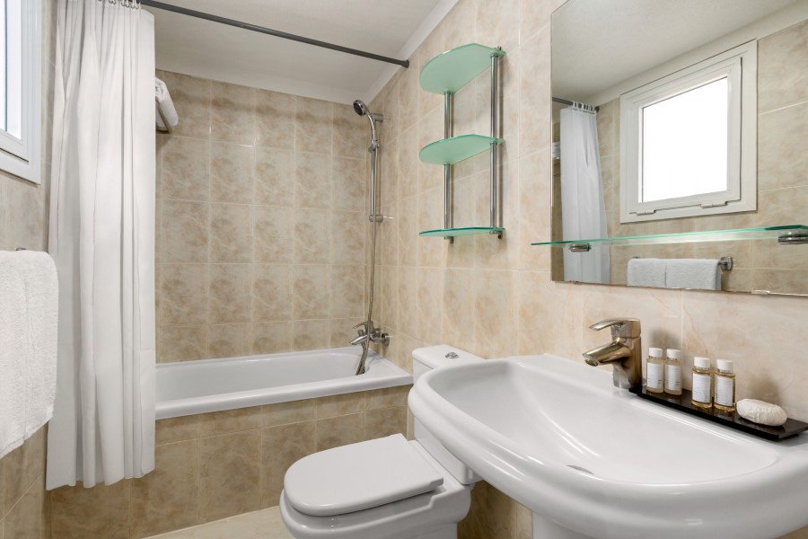 Tiled bathroom at Wyndham Residences Golf del Sur with sink, toilet, and shower over bath