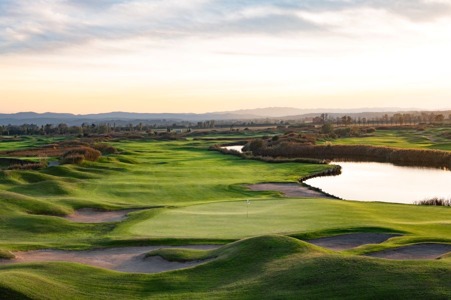 Green fairway with water to the right of it at Emporda Golf Course in Spain's Girona region