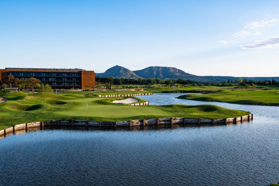 Club house at Emporda Golf Course in the distance beyond blue lake