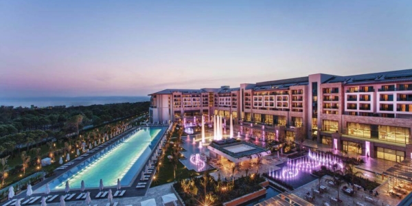 Regnum Carya Golf And Spa Resort at night with views over the swimming pool and sun loungers