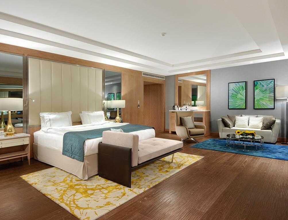 Double bedroom with desk, sofa and table at at Regnum Carya Golf And Spa Resort