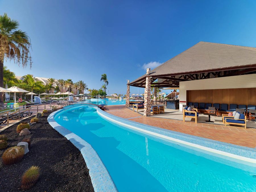 Pool bar with lagoon surrounding it at H10 Playa Meloneras Horizons Collection
