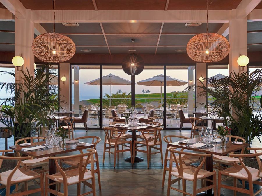 Wooden seats and tables at H10 Playa Meloneras Horizons Collection in the restaurant