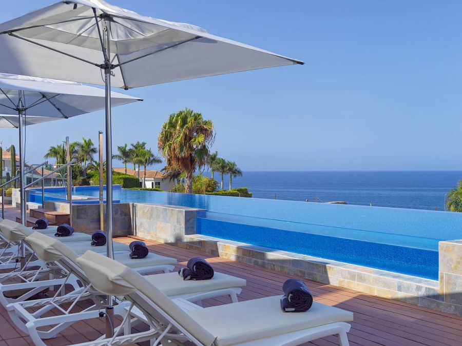 Sun loungers overlooking the pool, with views of the sea at H10 Playa Meloneras Horizons Collection