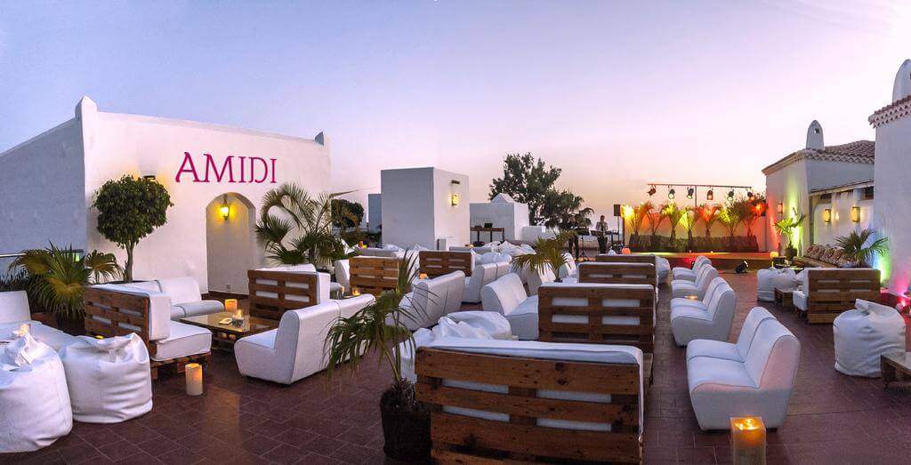 Candle lit Amidi bar at Hotel Jardin Tecina in the evening with white chairs,bean bags and wooden tables