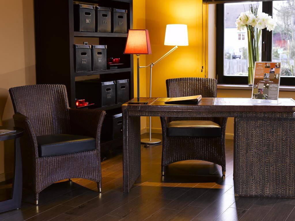 Martin's Waterloo brown desk and chair with lamps and flower on windowsill