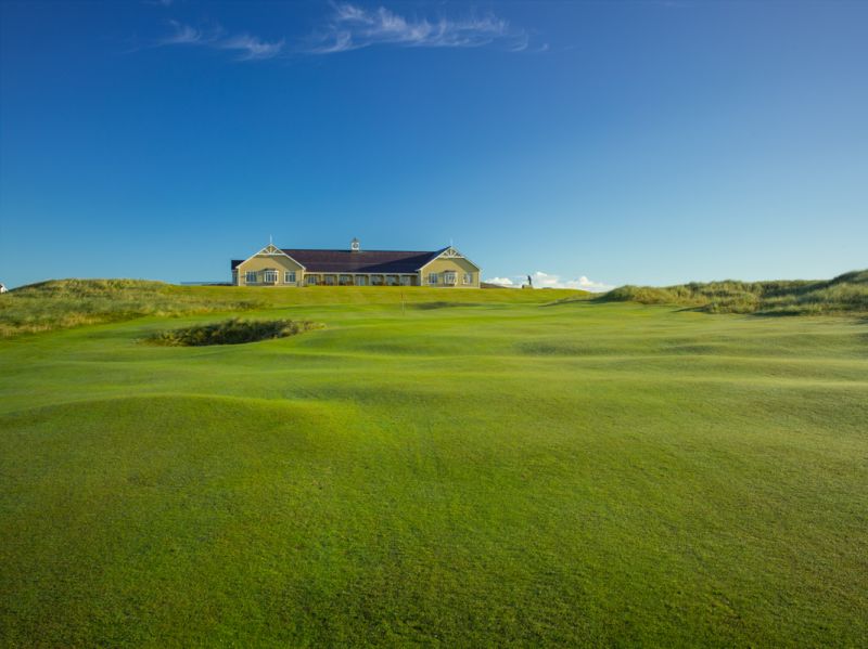 Clubhouse with blue sky and green fairway at Rosapenna Hotel And Golf Resort