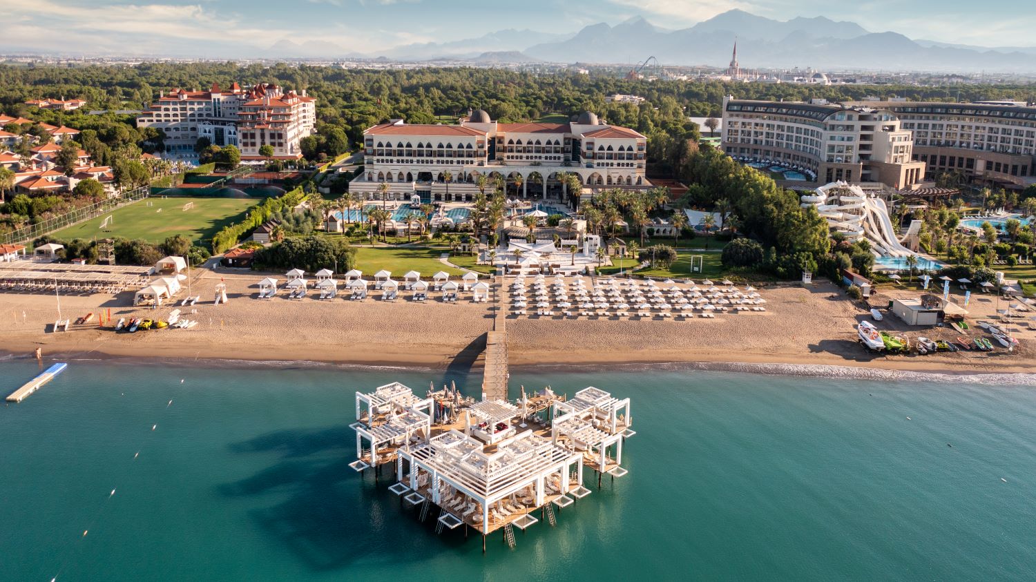 Beach and sea with pier in front of Kempinski Hotel The Dome in Belek