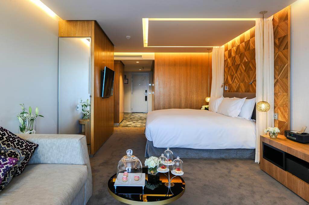 Hotel Sofitel Marrakech Lounge And Spa double bedroom with sofa, table, cake tray, flat screen television and bedside lamps