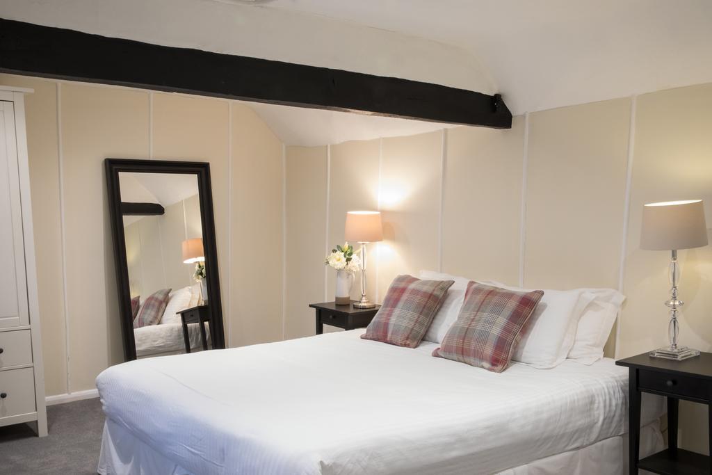 Double bedroom with wooden beam and mirror at Mannings Heath Golf & Wine Estate