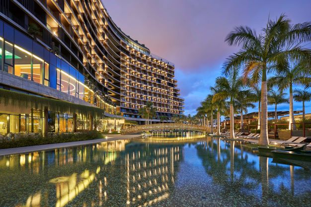 Savoy Palace in Funchal, Madeira at sunset with swimming pool overlooked by palm trees
