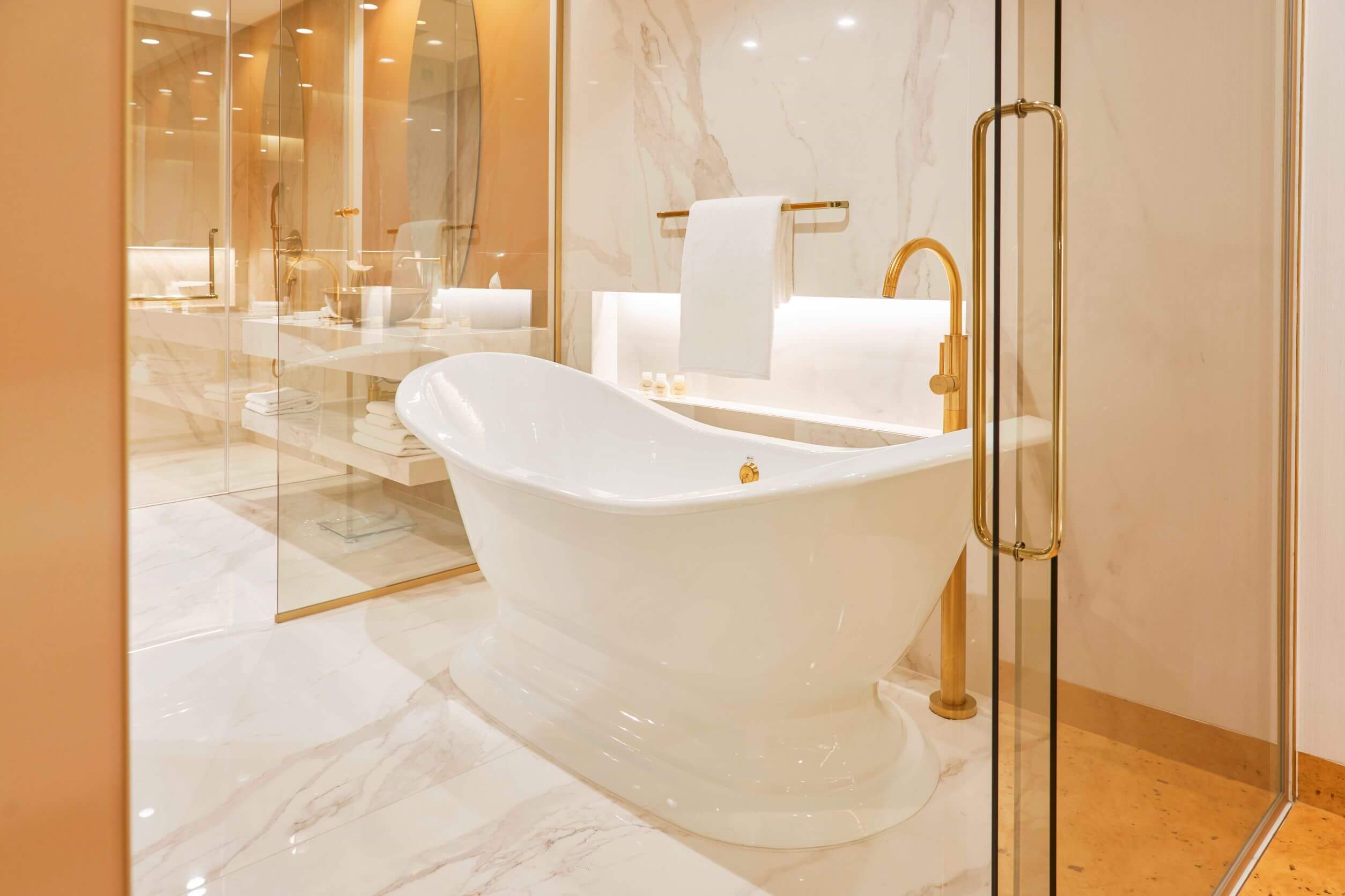 Bathroom in Savoy Palace in Madeira. White bathtub with gold taps and seperate shower unit