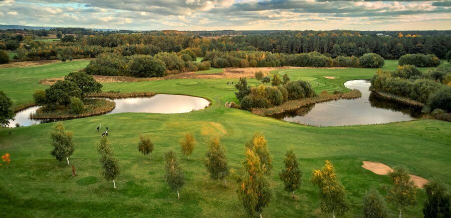 Overview of golf course at Sanburn Hall with trees decorating fairways and lakes protecting the green