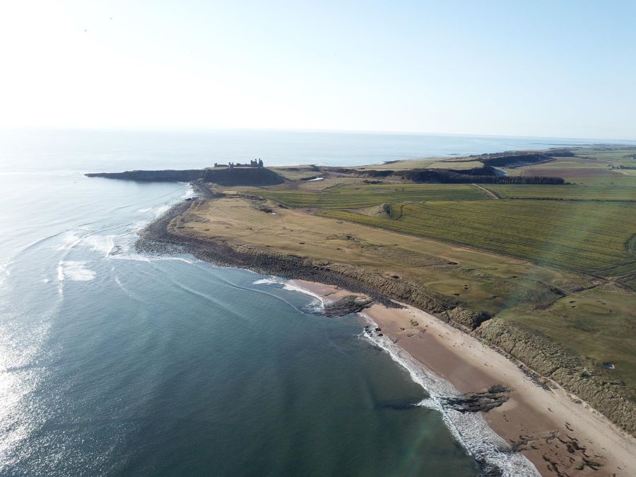 Dunstanburgh Castle Golf Club with the ruins on the clifftop in the background