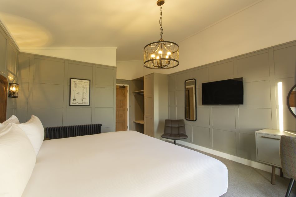 Bedroom with flat screen television and green wall panelling at Dundonald Links