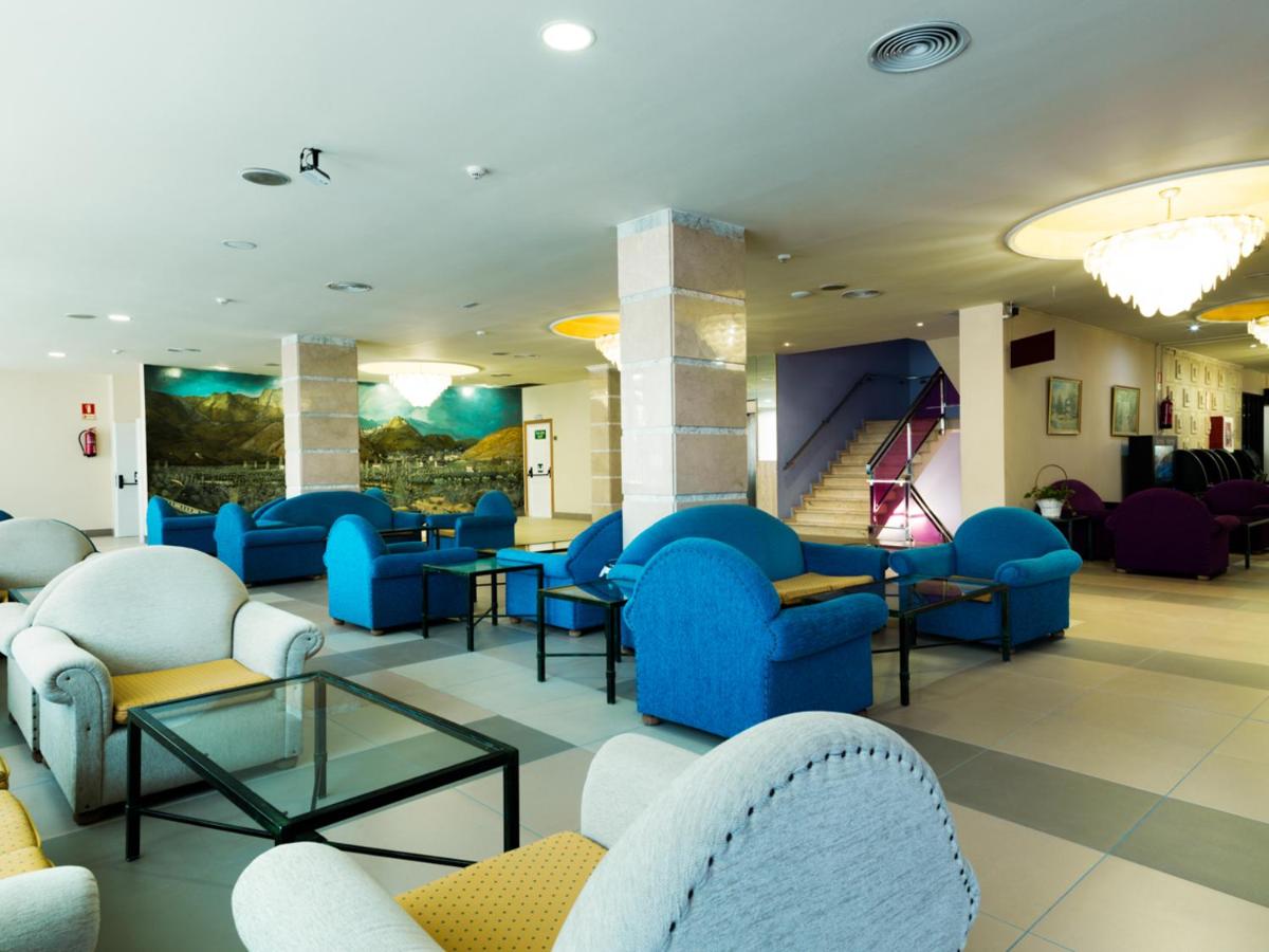 Lobby area with blue and grey armchairs at Hotel Monarque Fuengirola Park