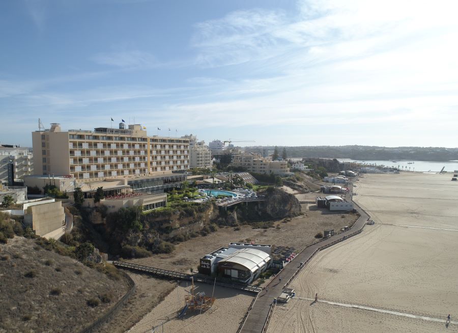 Beach with blue sky overhead and Hotel Algarve Casino in the distance