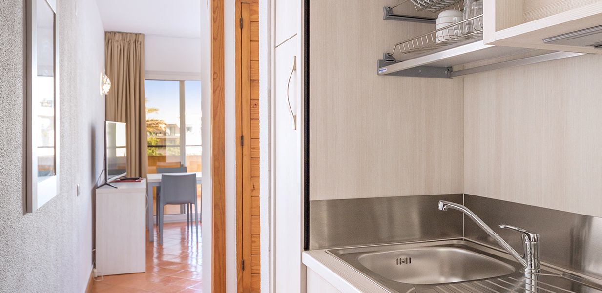Kitchenette in room with television in distance at Dom Pedro Lagos Hotel
