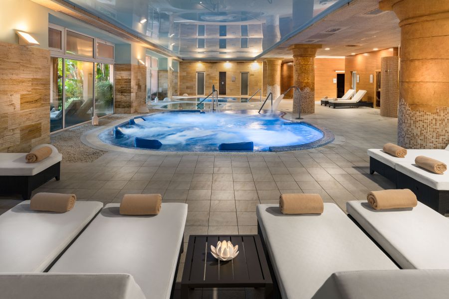 Indoor pool with sun loungers with towels on them at Elba Estepona Gran Hotel & Thalasso Spa