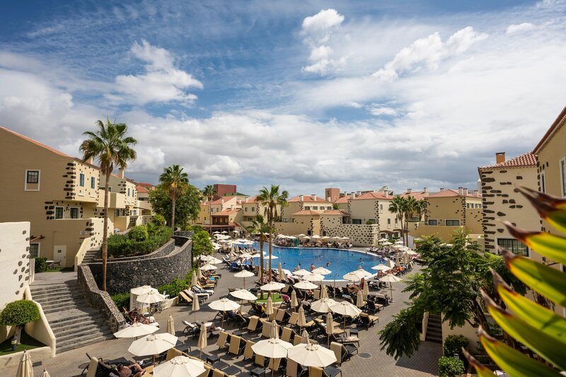 Sun loungers around the swimming pool and palm trees at GF Isabel