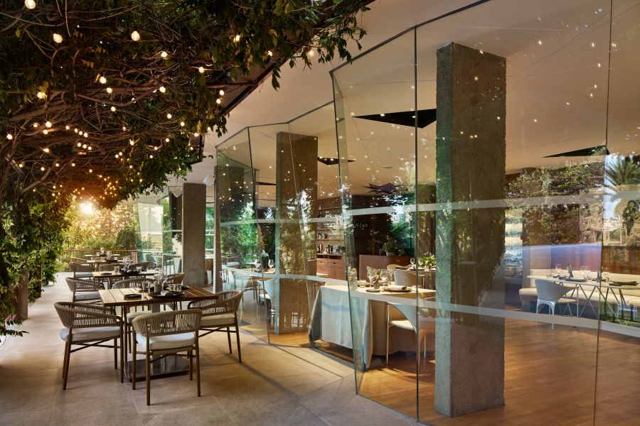 Restaurant with tables outside and greenery overhead at Melia Lloret De Mar