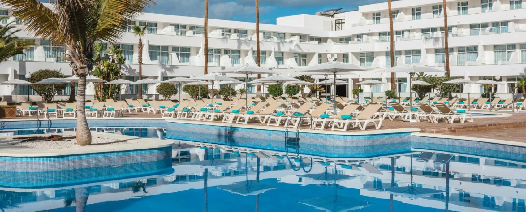 Swimming pool with sun loungers at Iberostar Waves Las Dalias